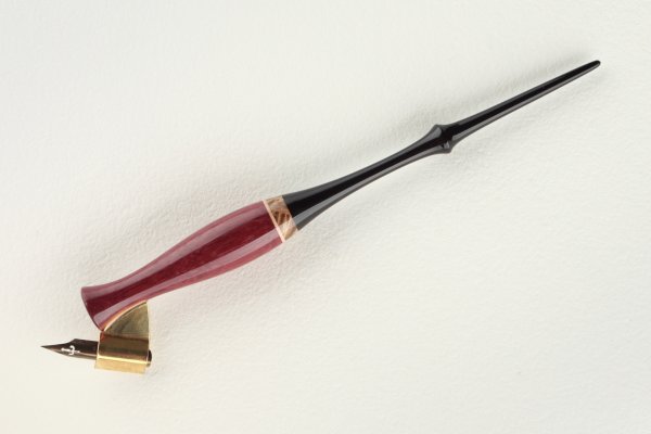 Oblique pen holder made of Amaranth, stabilized Maple Burl and Gabon Ebony wood, with a thin insert of Sycamore Maple wood.